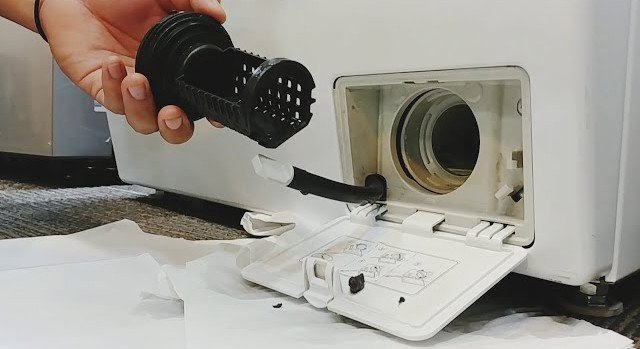 Filtro de drenaje de una lavadora LG retirado para su limpieza