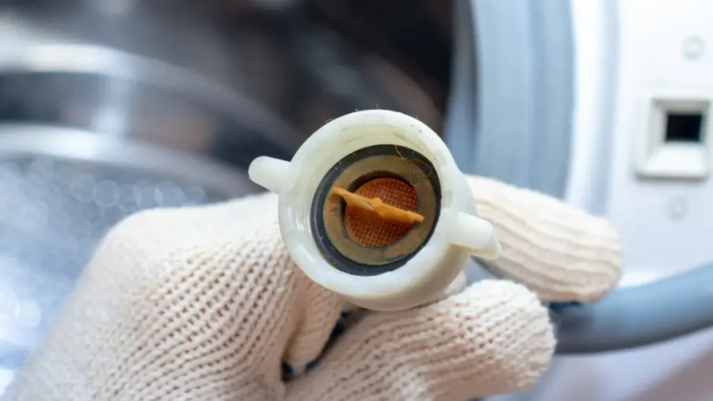 Filtro de entrada de agua de una lavadora con residuos acumulados